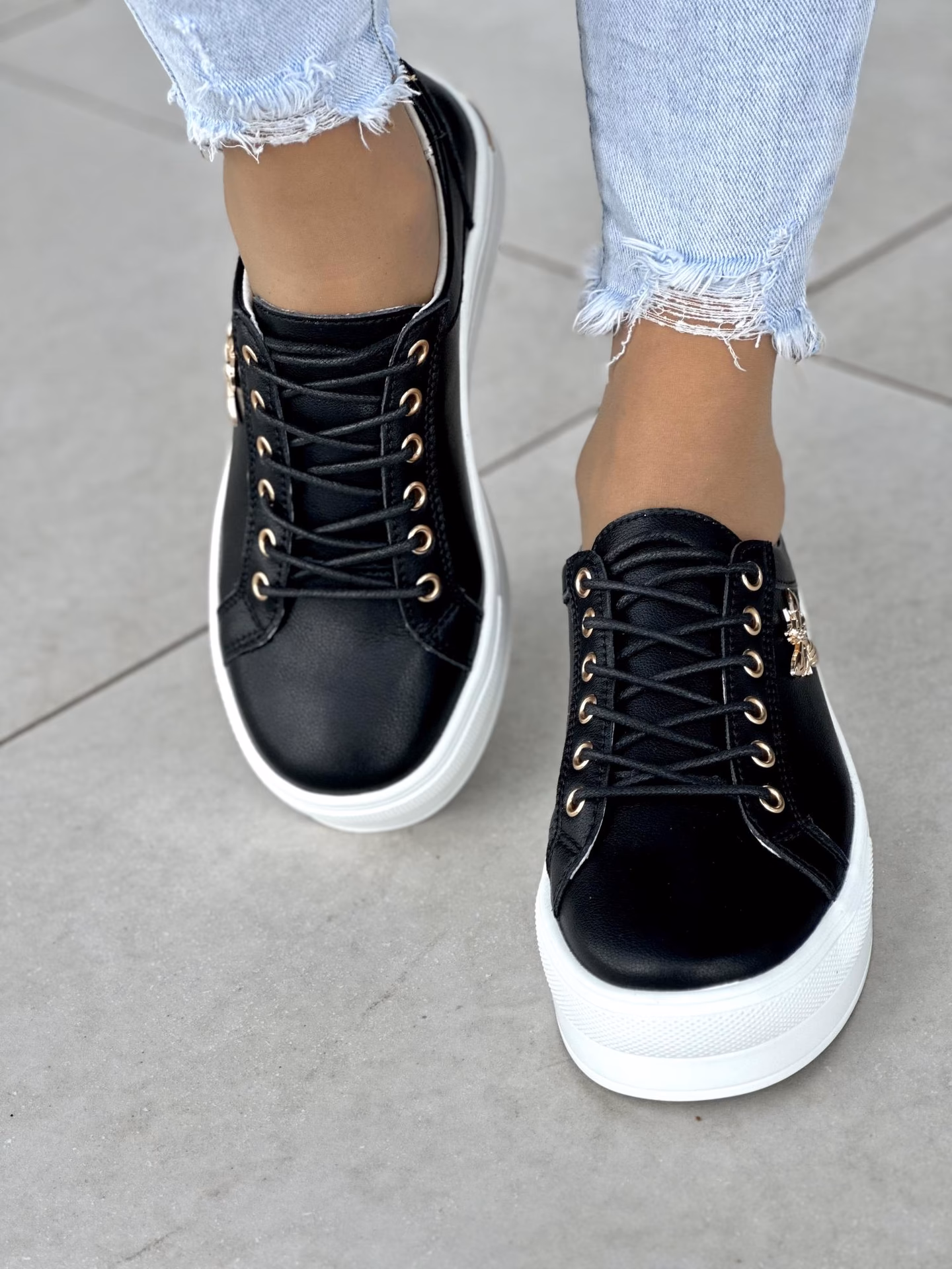 Do jakich stylizacji pasują czarne buty z białą podeszwą?